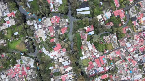 Jib-up-above-a-canal,-houses-and-chinampas-of-Xochimilco,-in-Mexico-City