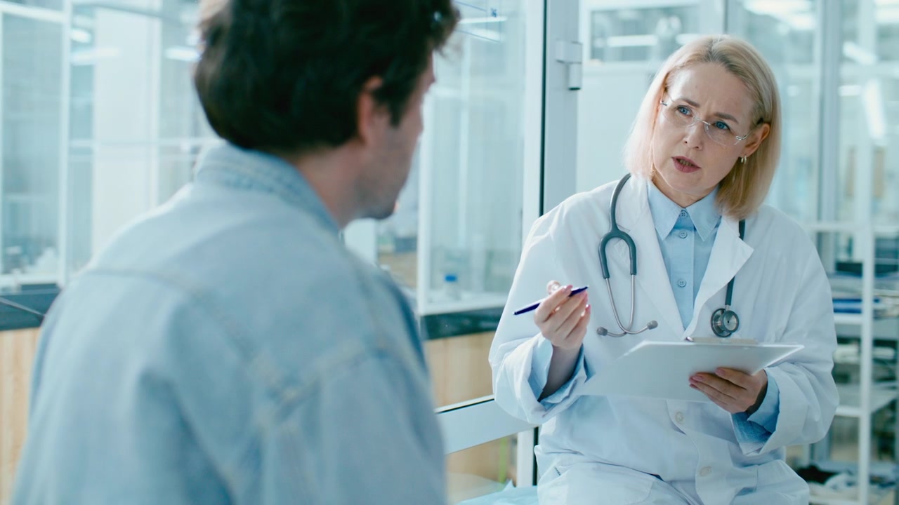 Female Doctor Asking Questions and Taking Notes during Patients Checkup