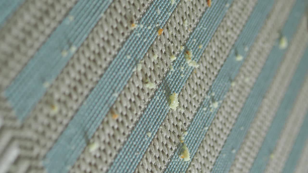 Primo piano di briciole sparse su una superficie a strisce con texture