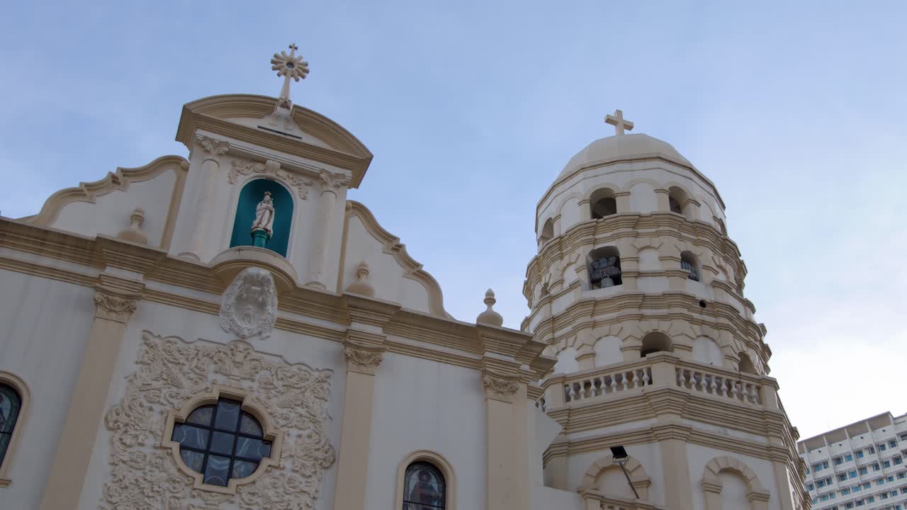Inquadratura dal basso della storica facciata della Chiesa di Quiapo sotto un cielo azzurro e limpido