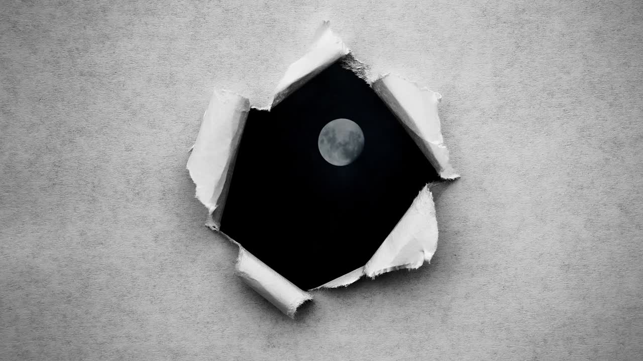 Creative 4k time laps video of a glowing full moon in the night sky with floating clouds, which is visible through a circle hole with torn edges in old retro grunge vintage paper.