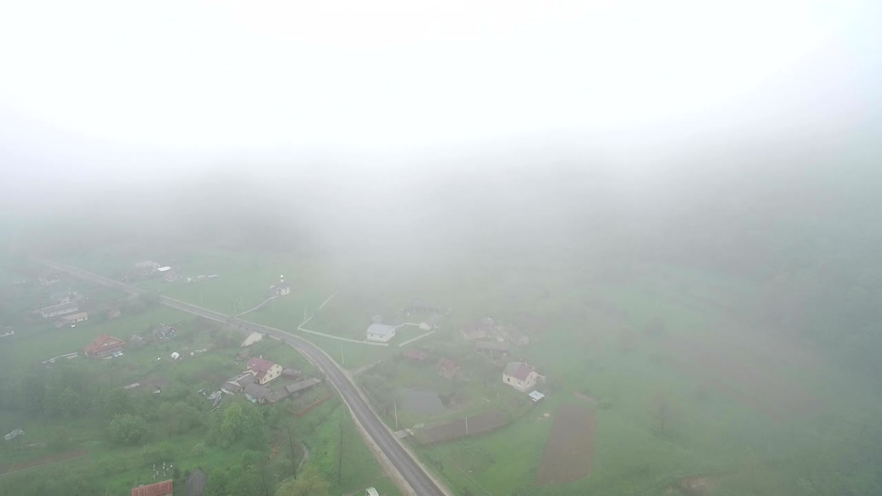 아침 안개 속에서 마을 위를 날아다니는 드론