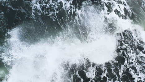 stunning drone shot of waves breaking on a beautiful ice rock at diamond beach in iceland