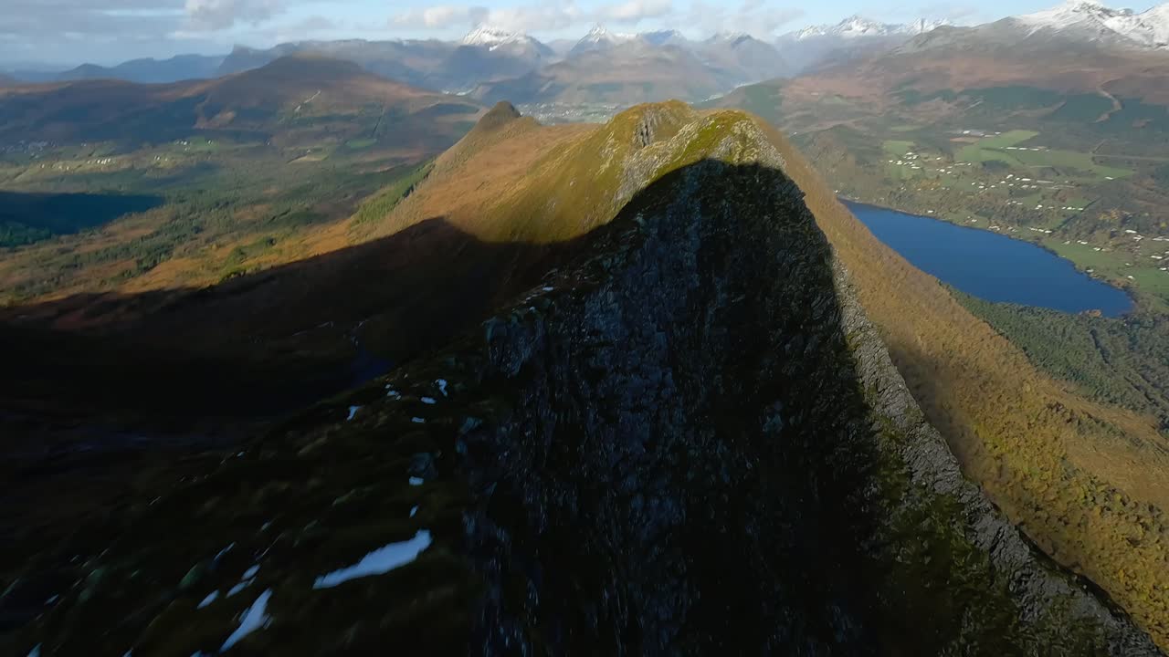 호수를 배경으로 노르웨이 산맥의 녹색 목가적인 정상을 넘는 화려한 fpv 비행