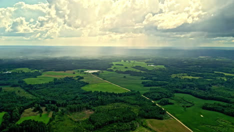 lush green fields and forests stretch out under a partly cloudy sky