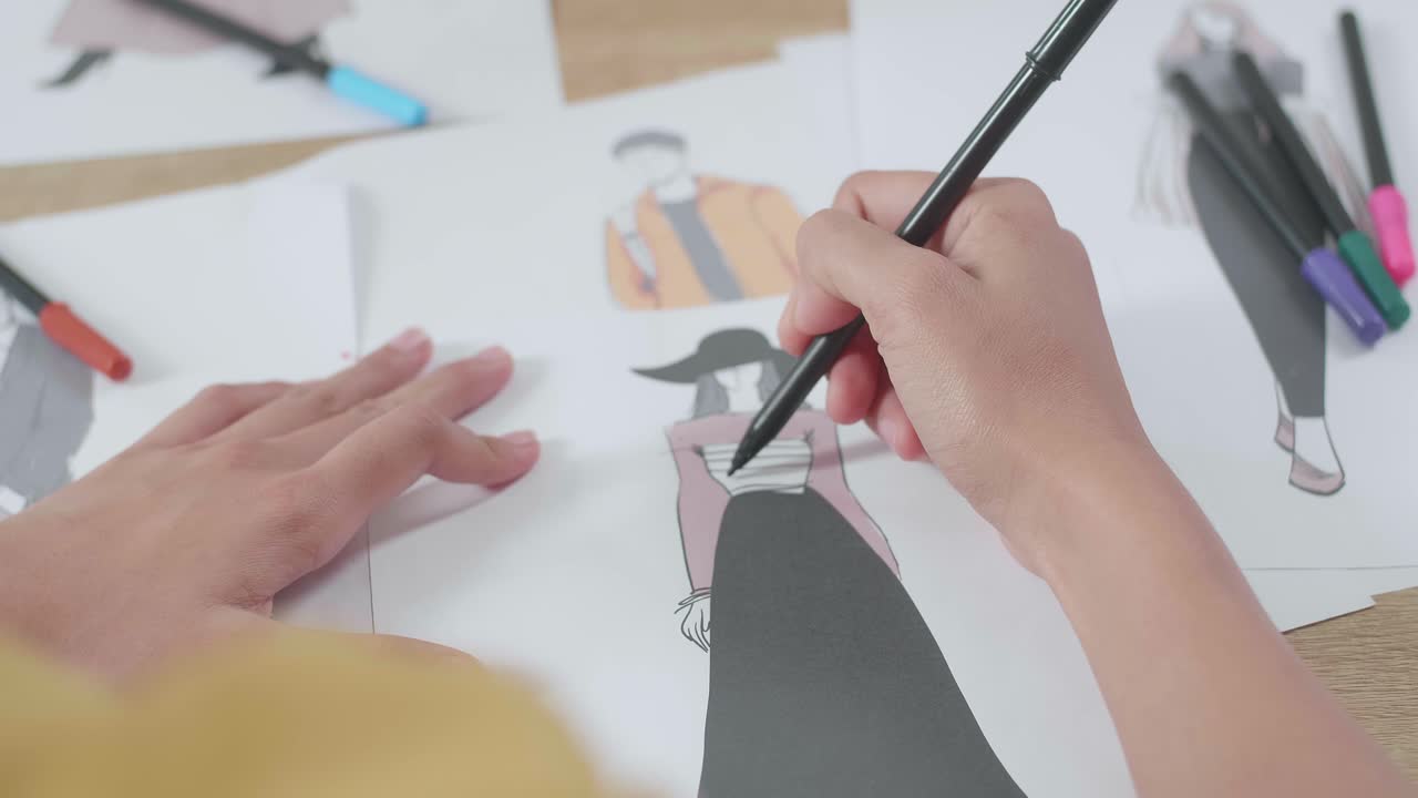 Close Up Of Female'S Hand Designing Clothes On The Paper In The Studio