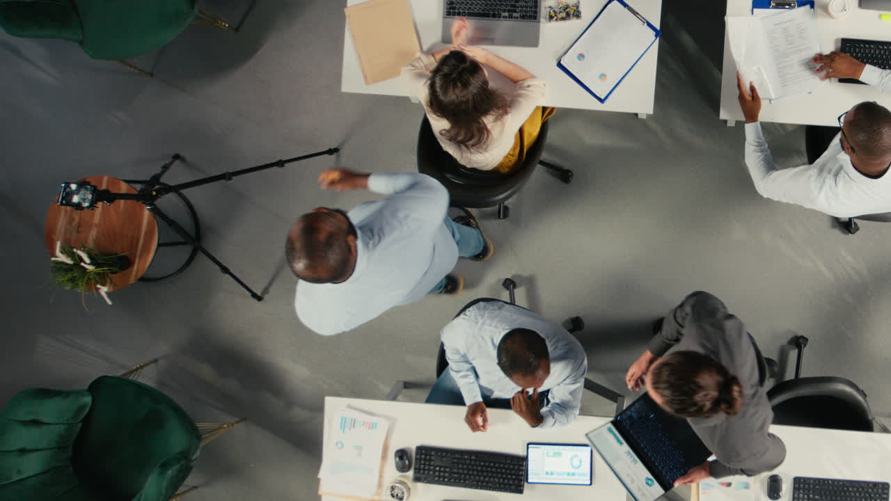 Vertical Video Top down view zoom out of diverse staff recording marketing ad