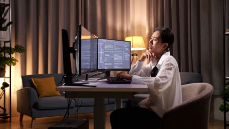 아시아 여성 프로그래머가 무언가에 대해 생각하고 집에서 데스크 컴퓨터에서 앱, 프로그램, 비디오 게임을 개발하는 소프트웨어 엔지니어를 만들면서 지표손가락을 들어 올립니다.