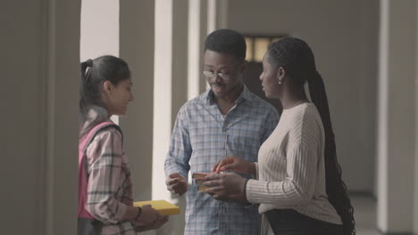 multicultural group of university students exchanging books