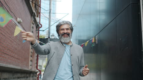 man celebrating in a city alleyway with brazilian flag decorations