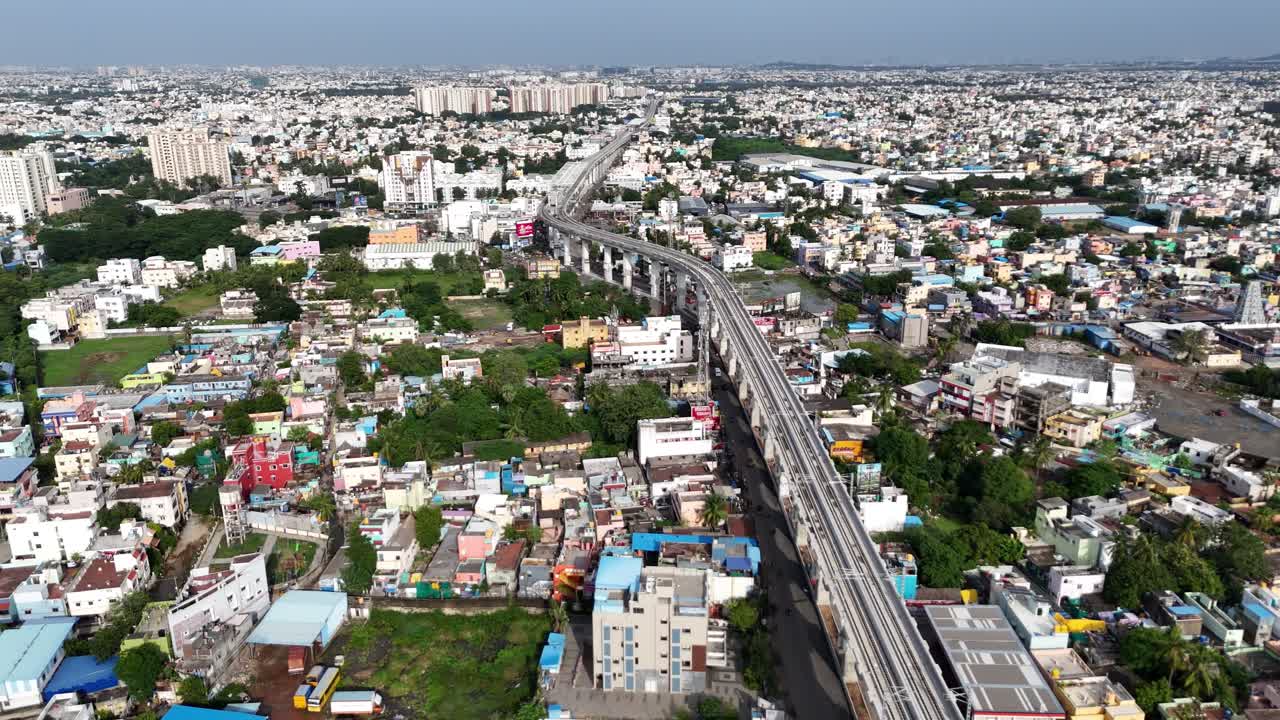 Based on the visual characteristics commonly associated with a large apartment complex next to an elevated metro line in the Porur area of Chennai, the building is most likely Prestige Bella Vista