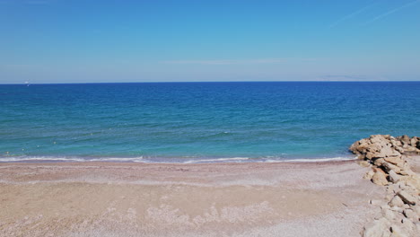 paisaje de playa tranquilo con cielos azules claros y olas suaves al mediodía
