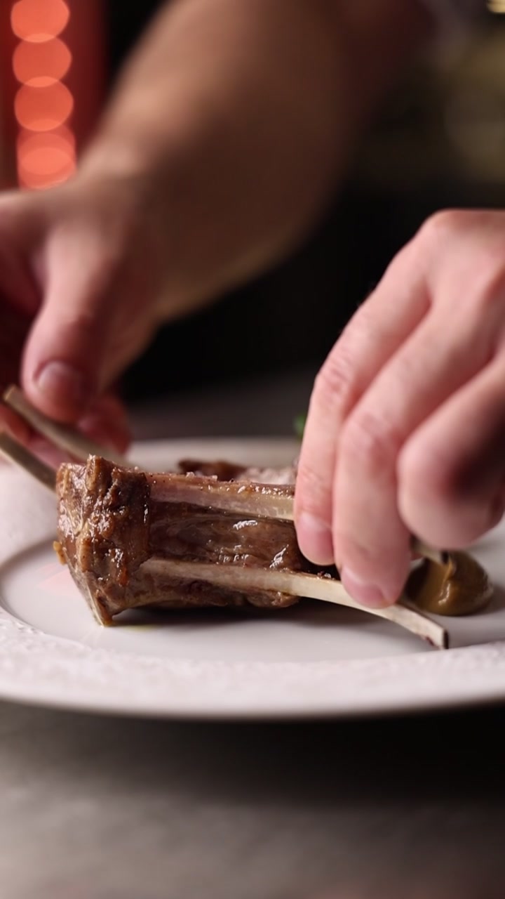 Chef Plating Grilled Lamb Chops in Professional Kitchen