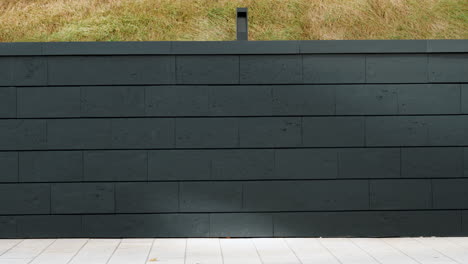 dark gray stone wall with grassy hill