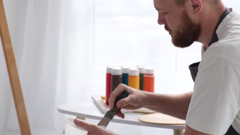 male artist paints a picture with oil paints artist while working in the studio male artist paints a picture with oil paints artist while working in the studio painting an art picture