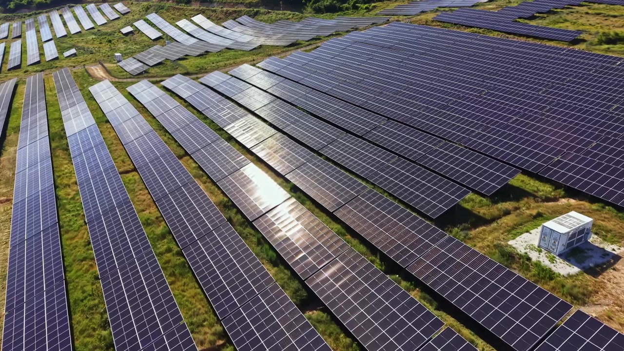 Solpaneler dækker et stort område på et vedvarende energifelt beliggende i en solrig region i dagtimerne, der viser ren energiteknologi i brug.