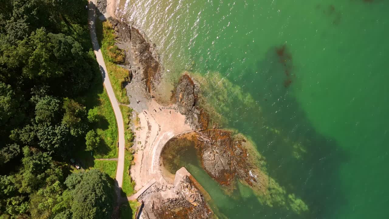 Overhead travelling aerial video of Helen's Bay beach in County Down, Northern Ireland, UK on a bright summer day. Filmed in 4K, 60FPS and with Rec709 color