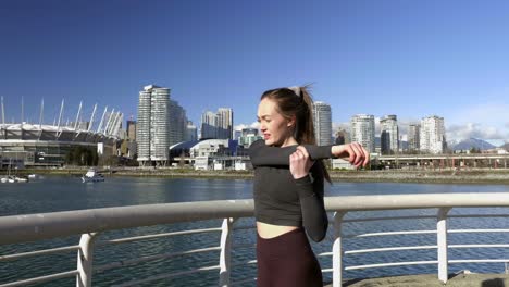 young athletic woman stretching arms deltoids before running