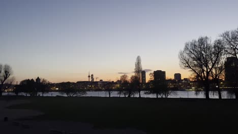 Rheinpark-Am-Abend-Mit-Sonnenuntergang-Vor-Der-Kölner-Skyline