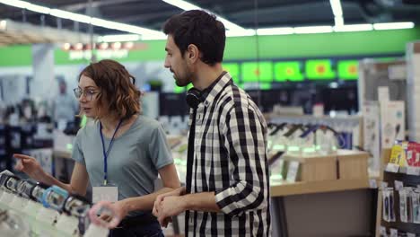 una consultora le da consejos profesionales a un joven que considera comprar un nuevo reloj inteligente y necesita un experto.