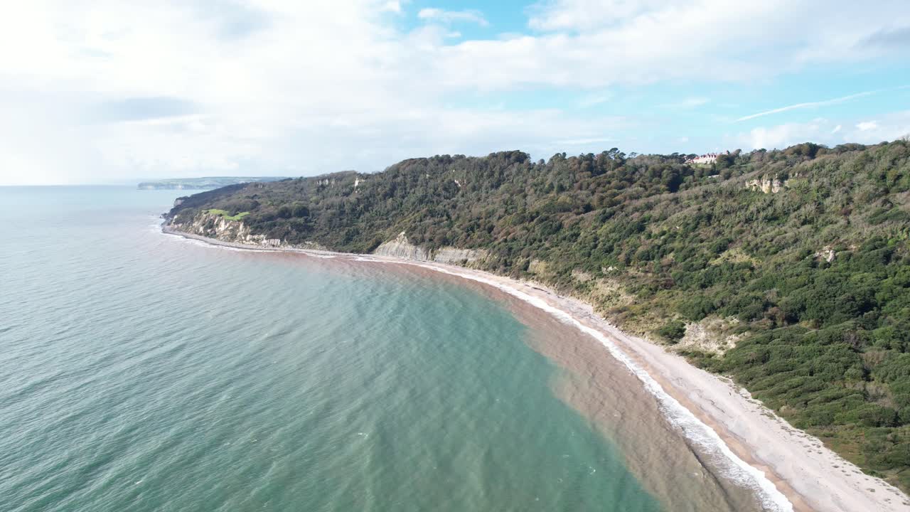 Aerial drone view of Lyme Regis and Seaton undercliffs coastline meeting English Channel in Dorset, United Kingdom