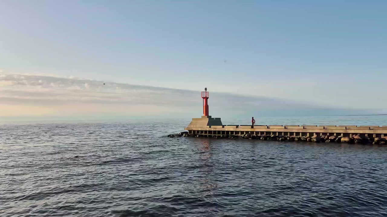 Vue d'une belle journée d'été du phare de Pavilosta sur la côte de la mer Baltique en Lettonie. Paysage côtier pittoresque capturant le phare historique, le ciel bleu, les vagues de la mer et l'atmosphère paisible