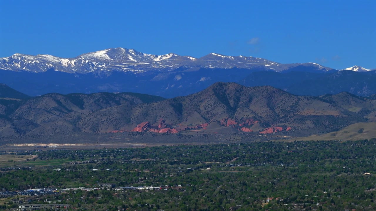 Pedemontana di Denver Colorado, Front Range delle Montagne Rocciose, drone aereo, stagione primaverile, Monte Blue Sky innevato, punto di riferimento Parco e Anfiteatro Red Rocks, paesaggio di Morrison Lakewood Littleton, virata a destra.