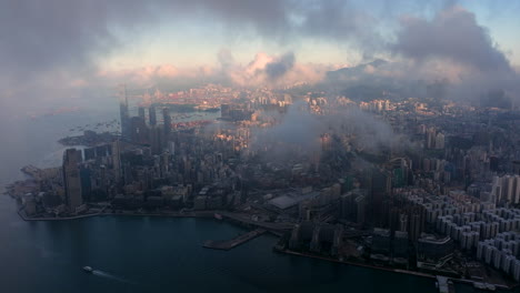 beautiful cinematic establishing shot through the moody clouds over kowloon, hong kong city