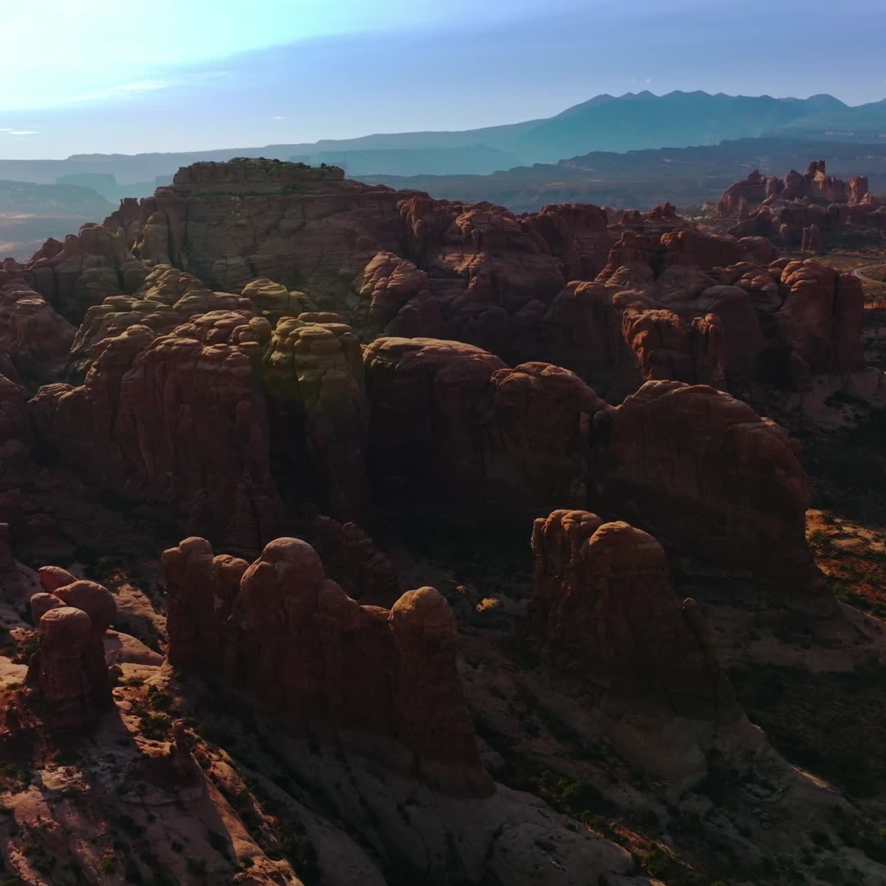 Rounded red rocks in Utah, USA in the rays of bright sun. Arches National Park at the backdrop of blue skies. Aerial view