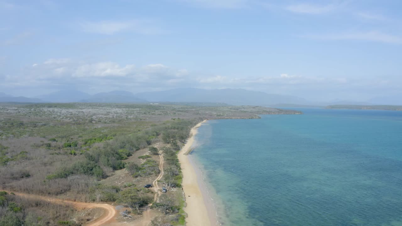 un paisaje de una hermosa playa de arena blanca y el océano durante un día soleado en una zona tropical
