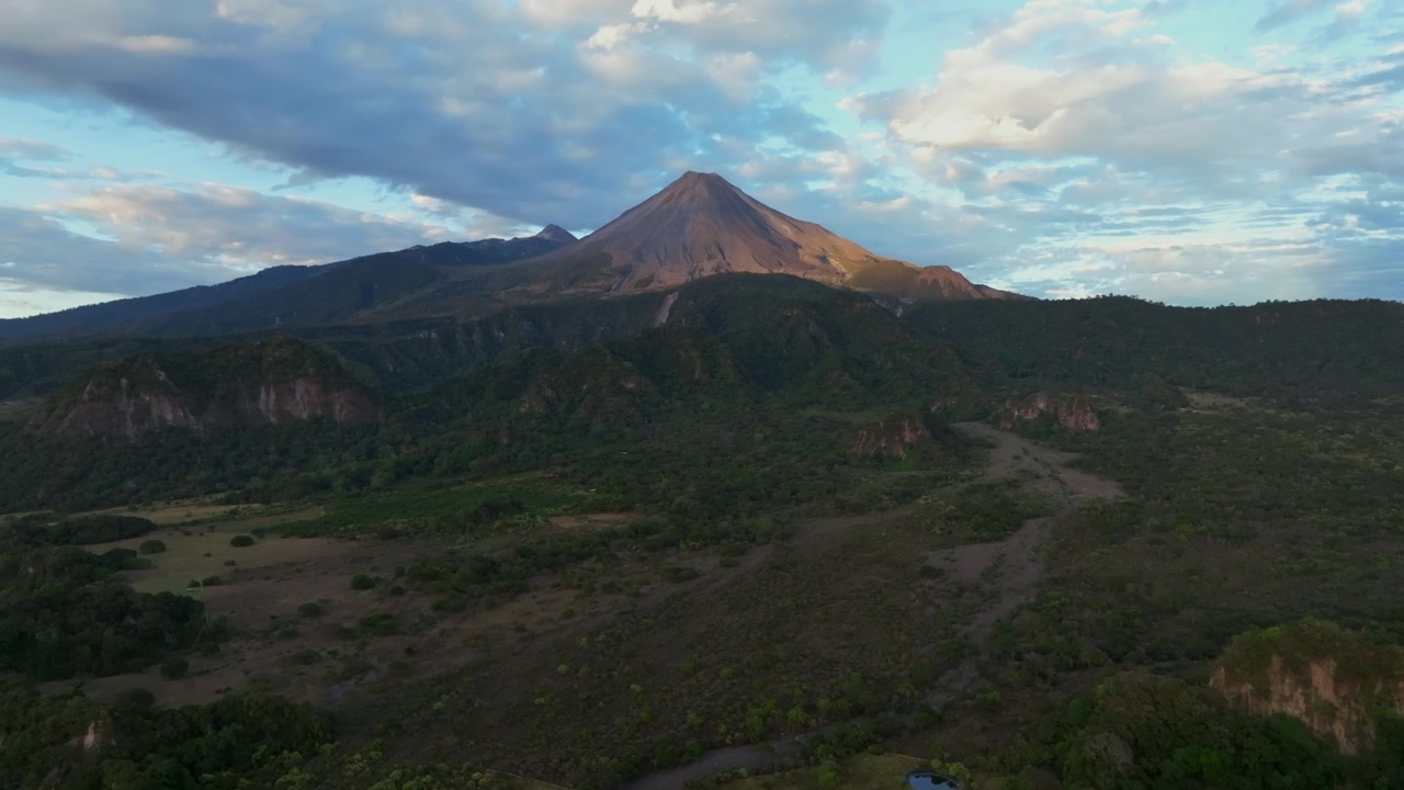 Ripresa aerea in dolly verso il lato occidentale del Volcan de Colima, che mostra le calde tonalità dell'alpenglow e la bellezza vulcanica