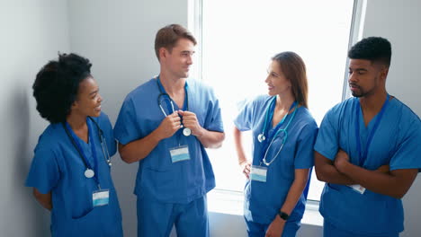 Portrait-Of-Smiling-Multi-Cultural-Medical-Team-Wearing-Scrubs-Standing-On-Stairs-In-Hospital