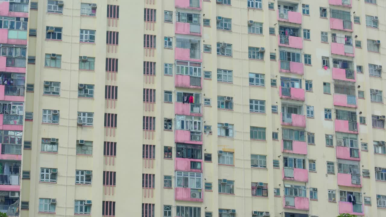Vista panorâmica de edifícios de apartamentos e arranha-céus no centro de Hong Kong, China, em um dia ensolarado, mostrando a densidade da vida urbana e a arquitetura moderna.