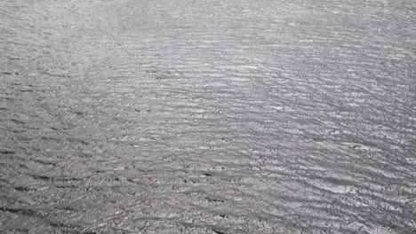 Aerial-view-to-ocean-waves-Rippled-water-with-birds-flying-over-surface