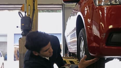 handsome mechanic overhauling a car