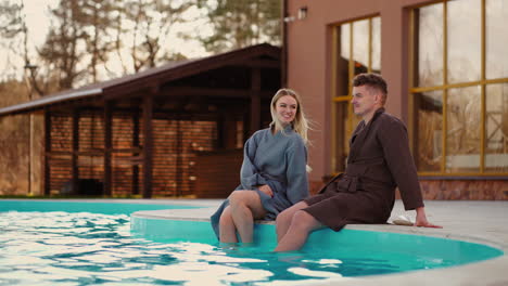 lovers are resting in thermal spa complex showing legs in warm water of outdoor swimming pool