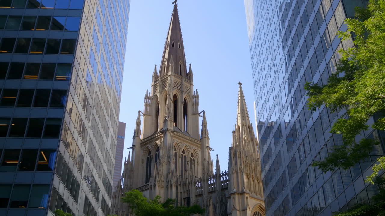 Agujas de catedral gótica se elevan entre rascacielos de ciudad moderna