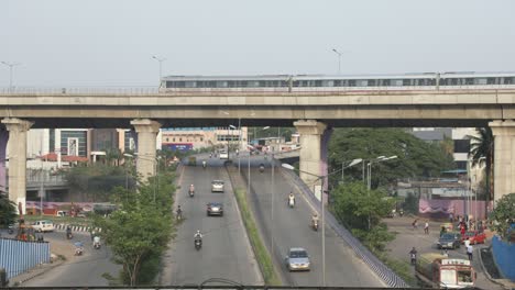 Timelapse-of-busy-four-line-highway-traffic-with-a-metro-train-on-the-bride-in-Bengaluru,-India