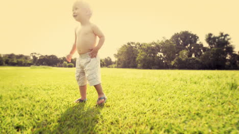 cute baby boy running in grass field