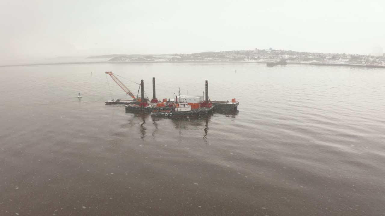 춥고 눈 내리는 겨울날 대서양에서 바지선을 돌고 있습니다.