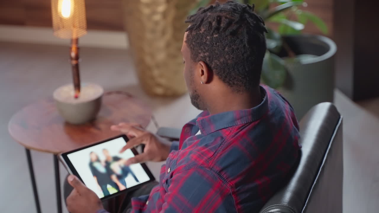 Man looking at photos on a tablet in a living room