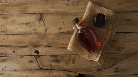 Video-of-maple-syrup-in-bottle-and-fabric-on-wooden-surface