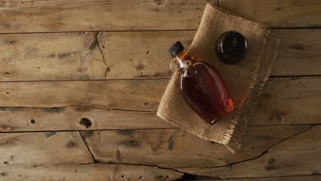 video of maple syrup in bottle and fabric on wooden surface