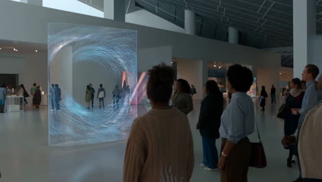 people observing dynamic digital art in a modern museum exhibit