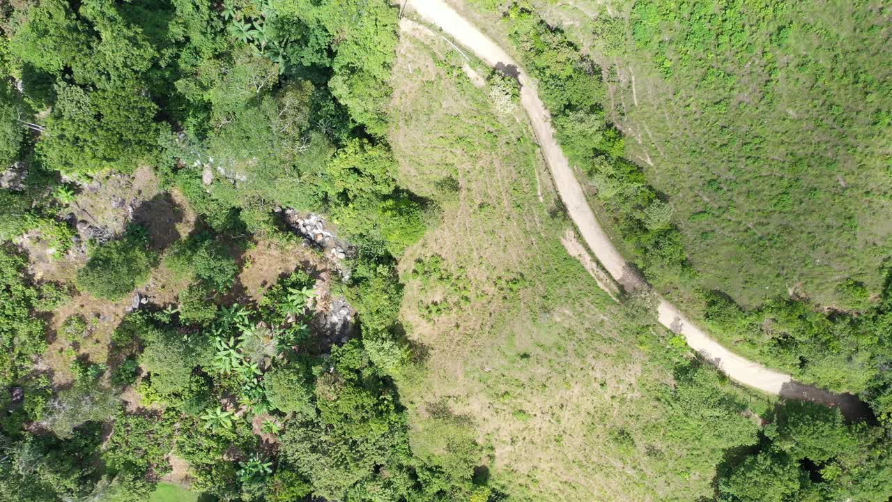 drone a vista de pájaro disparado dentro de las montañas, visualizando un camino rústico