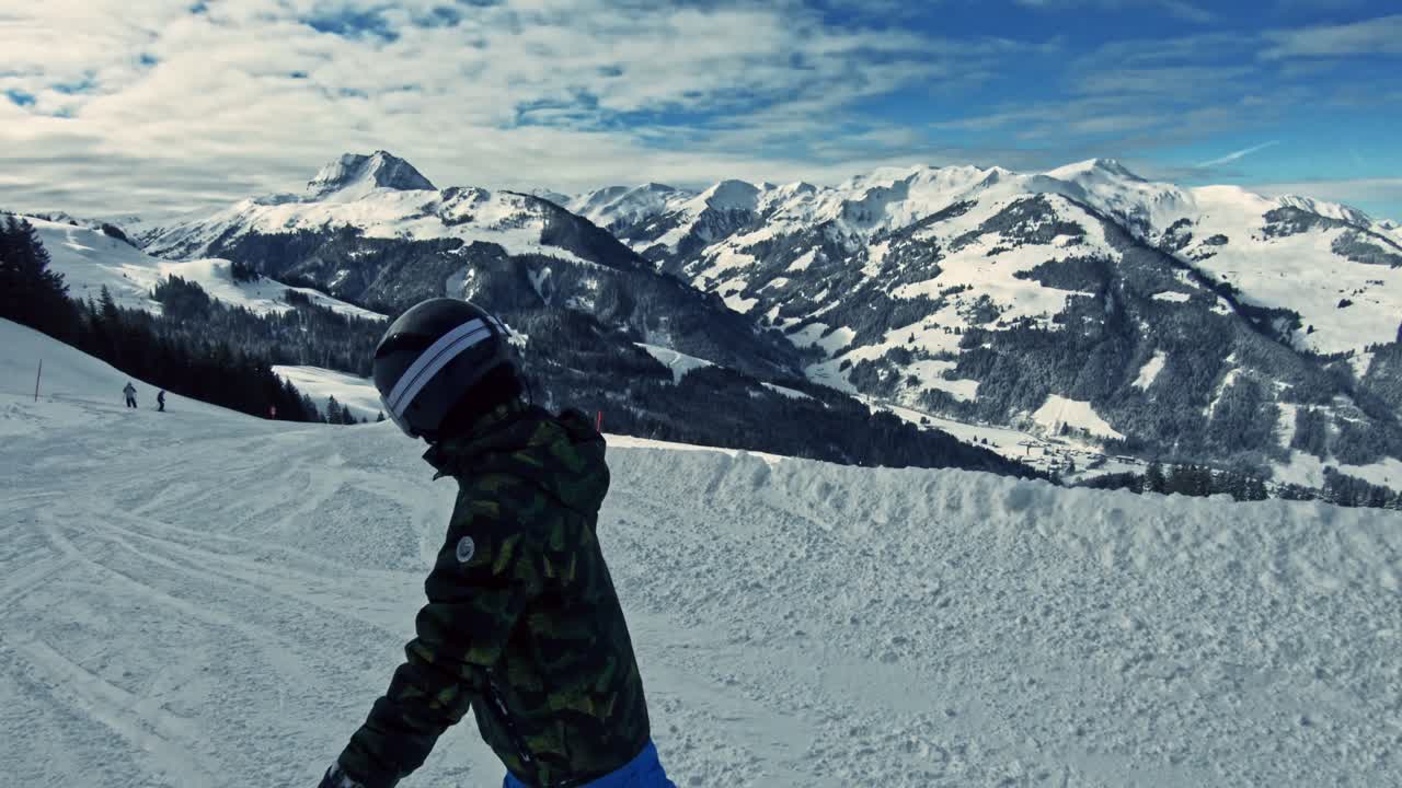 Un bambino che fa snowboard lungo la pista da sci