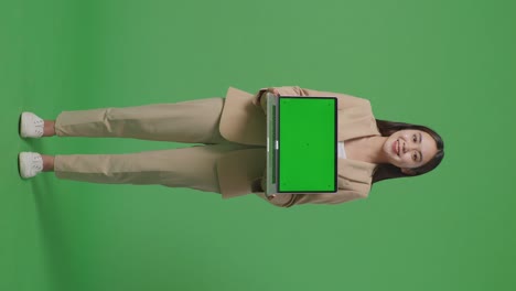 full body of asian business woman showing laptop green screen on green screen background in the studio