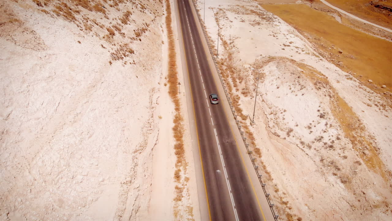Car driving on Straight line Highway in the desert aerial view