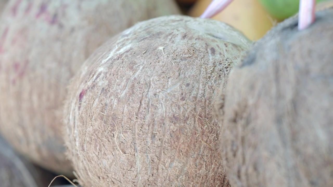 Close-up of Fresh Coconuts with Straws Ready for Drinking