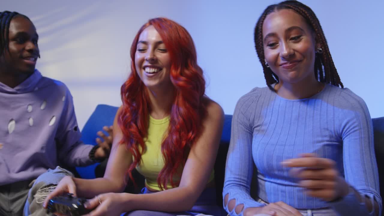 집에서 소파에 앉아 게임을 하고 피자를 먹는 z 세대의 친구들